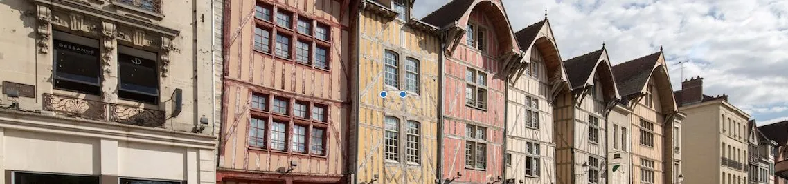 Rangée de maisons à colombages colorées bordant une rue de centre-ville européen